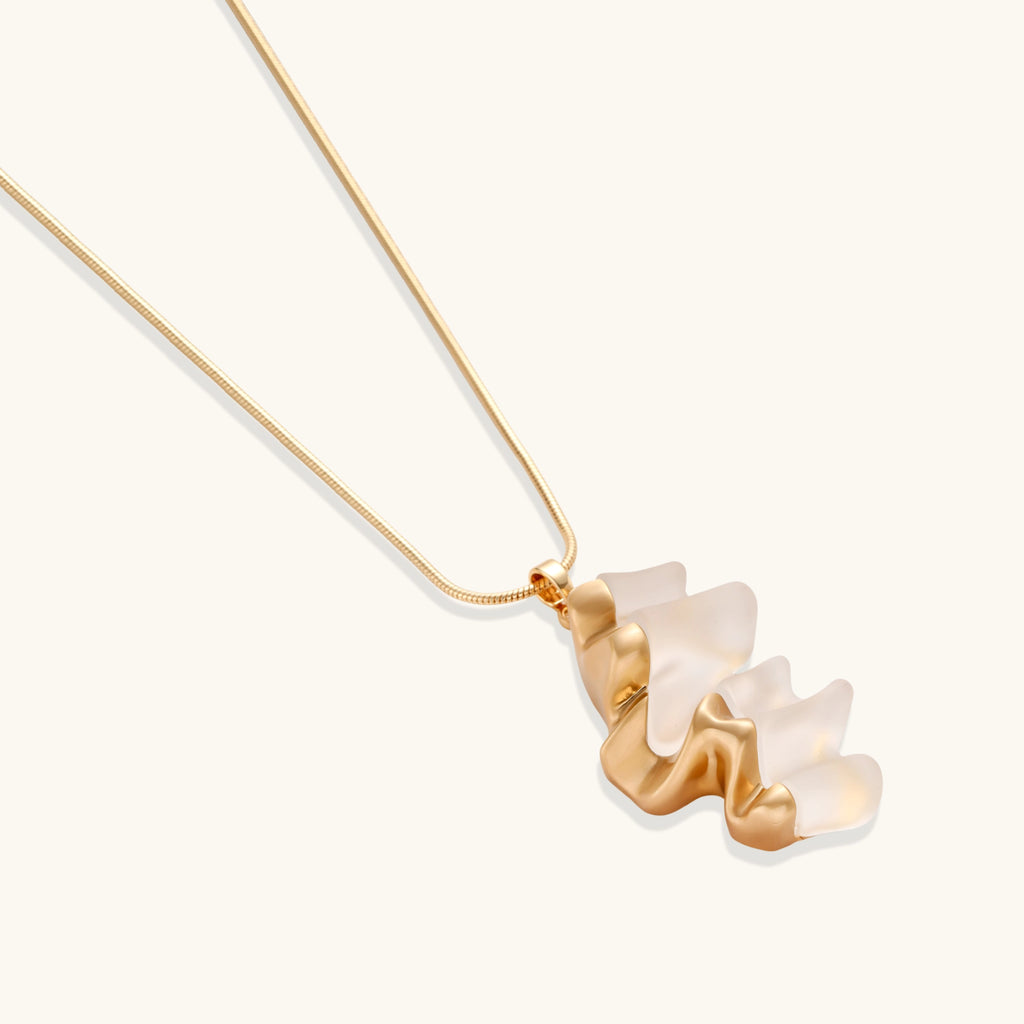 Close-up of a sculptural necklace with flowing wave pendant made from eco-zinc alloy on adjustable chain