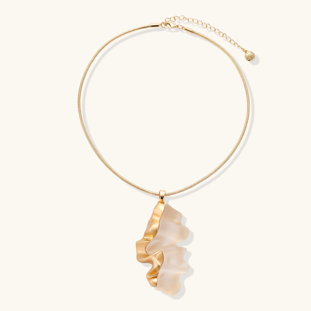 Close-up of a sculptural necklace with flowing wave pendant made from eco-zinc alloy on adjustable chain