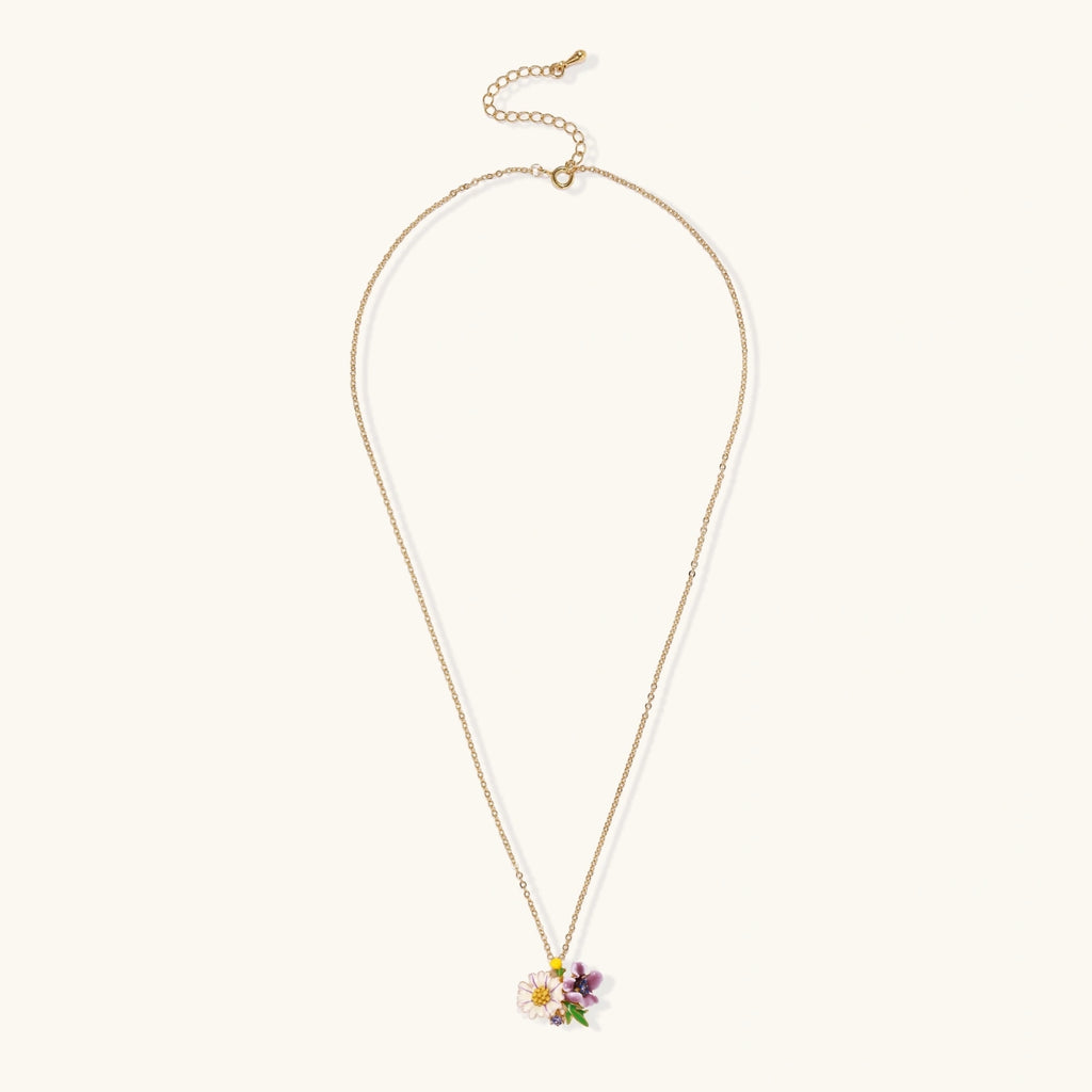 Gold-plated necklace with pink and purple enamel flower pendant featuring crystal accents on cream background